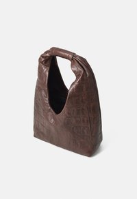 Bruine krokodillenleer tas met een unieke, gebogen vorm en een handvat bovenaan. Heeft een open bovenkant en subtiele naaiachtige details.