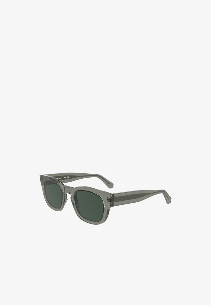 Óculos de sol cinzas com armações quadradas, lentes escuras e um acabamento brilhante. Apresenta hastes grossas com uma marcação discreta na lateral.