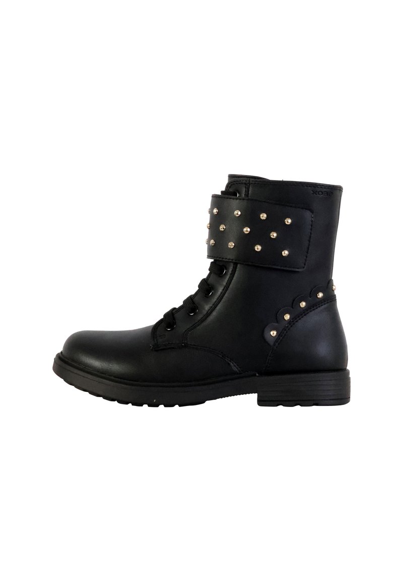 Botas negras hasta el tobillo con un acabado de cuero liso, parte delantera con cordones, tachuelas metálicas en la correa del tobillo y un tacón bajo y grueso.