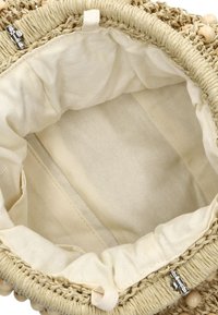 Geweven rieten tasinterieur met beige stofvoering, een gestrikte bovenkant en zilveren hardware. Heeft een gladde textuur en een lichte kleurenschema.