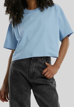 Lyseblå cropped t-shirt i blød bomuld med korte ærmer og rund halsudskæring; har subtil hvid broderi på brystet.