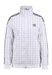 Vit Adidas trackjacka med svart rutmönster, svarta ränder på axlar och ärmar, framzipper och Adidas-logotyp på vänster bröst.
