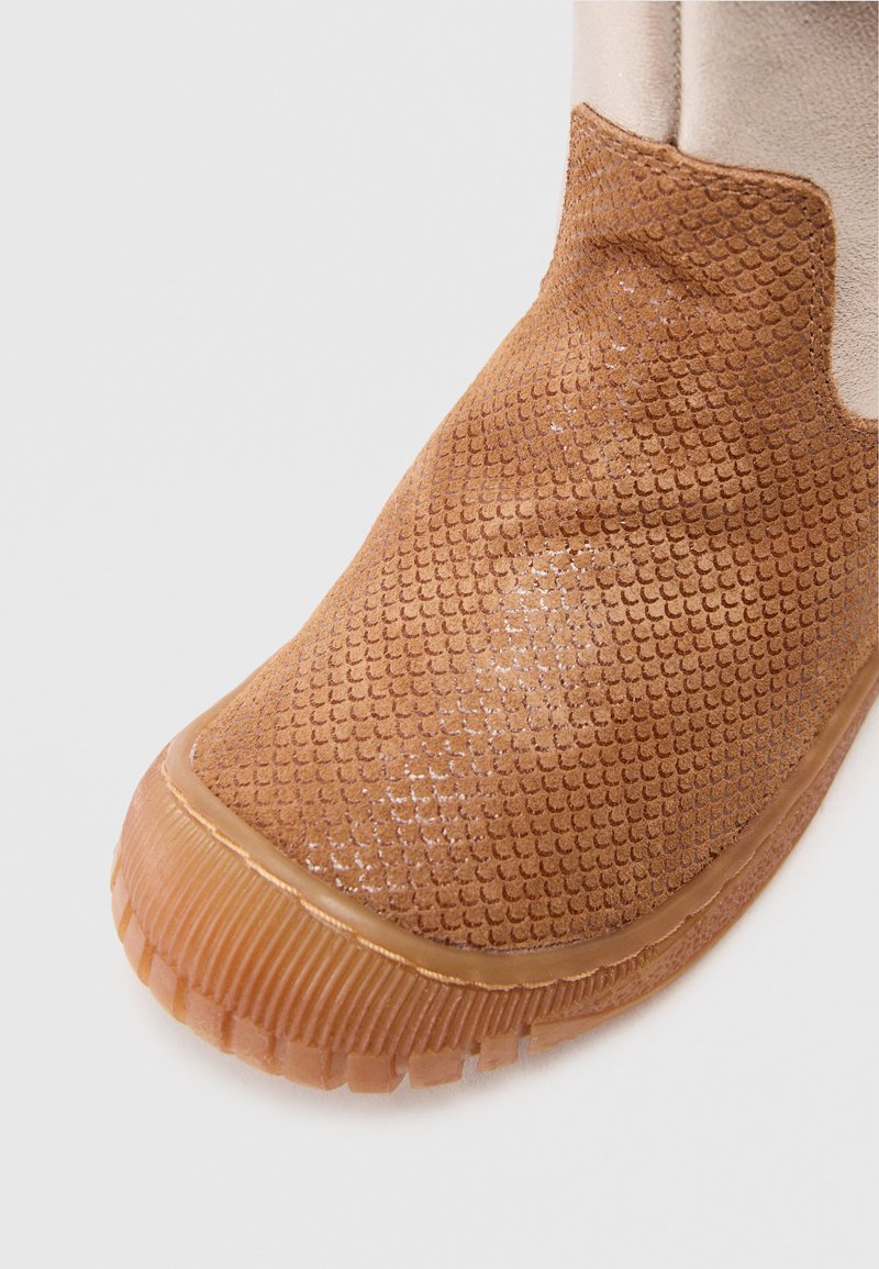 Brauner strukturierter Stiefel mit Gummisohle, der ein flaches Design und kleine Muster aufweist. Obermaterial glatt mit einem leichten Glanz.