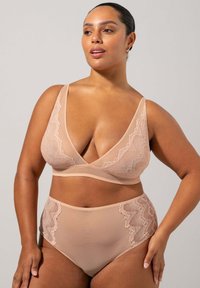 Trådslös bh och högmidjade trosor i nude, tillverkade av mjukt tyg med spetsdetaljer och en djup urringningdesign.