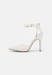 Scarpa con tacco alto in satin bianco, con punta affusolata, dotata di un pannello in rete e di un cinturino alla caviglia decorato con perle e hardware ornamentale.