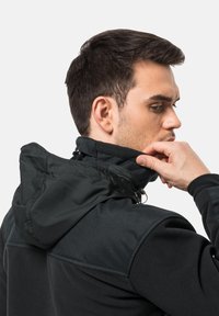 Zwarte fleecejas met capuchon, zachte textuur, hoge kraag, kinbeschermer en subtiele stikdetails. Voorzien van elastische sluitingen.