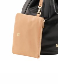 Borsa a tote in pelle nera con una pochette in pelle nuda staccabile, dotata di zip e logo impresso, che mette in evidenza colori e texture contrastanti.