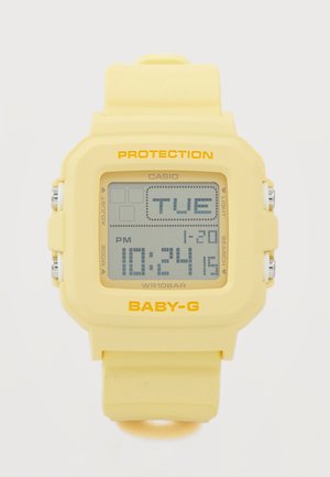 Gele Casio Baby-G digitale horloge die 22:24 uur aangeeft, dinsdag 20-01, met vierkante wijzerplaat en rubberen band.