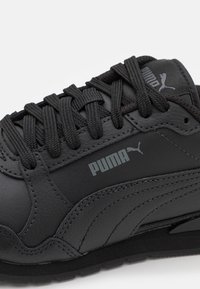 Czarne skórzane sneakersy o teksturowanej powierzchni, z okrągłymi sznurowadłami, wyściełanym kołnierzem, szarym logo i subtelnymi detalami w postaci przeszyć po bokach.