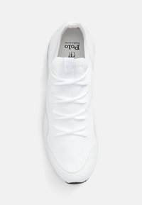 Baskets blanches avec un dessus en tissu texturé et des lacets plats. Dotées d'un bout arrondi et d'une semelle noire. Logo visible à l'intérieur de la chaussure.