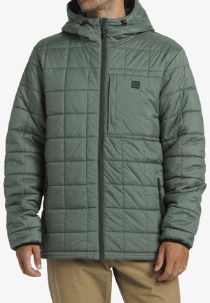 Chaqueta acolchada verde con capucha, cierre frontal, bolsillo en el pecho y dos bolsillos laterales; presenta un exterior suave y puños elásticos para mayor calidez.