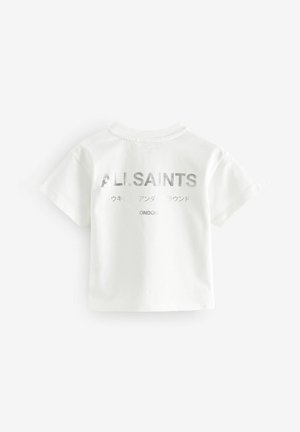 Fehér pamut póló rövid ujjal. A hátsó részén fémborítású ezüst betűkkel "A.L.ISAINTS" és "LONDON" felirat található. Simább textúrájú.