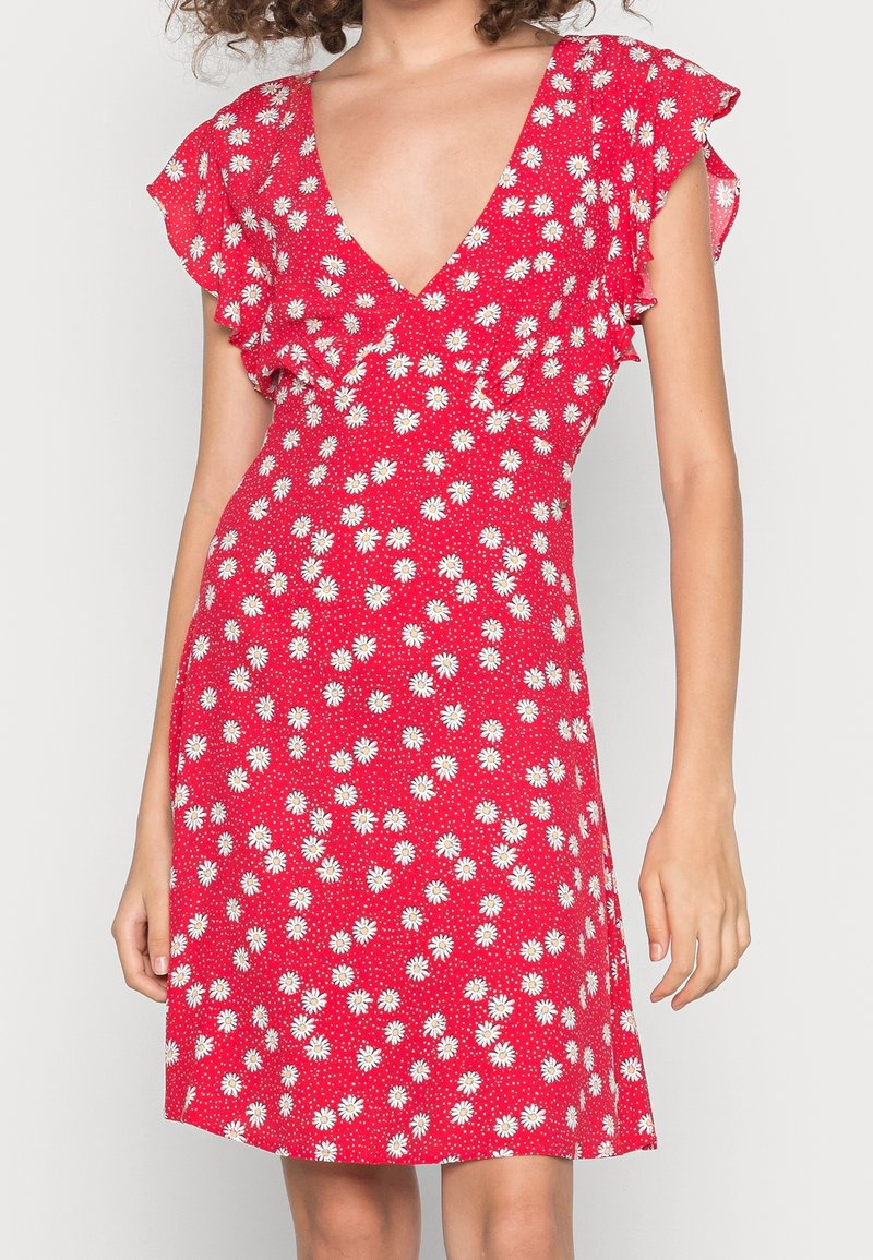 Red floral dress with ruffled short sleeves, deep V-neck, and white daisy patterns on a dotted background, featuring a flared skirt.