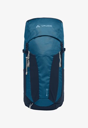 Zaino di colore verde scuro con parte superiore imbottita, tasche laterali in rete, due cerniere grigie e fondo piatto per stabilità. Logo del marchio esposto in maniera prominente.
