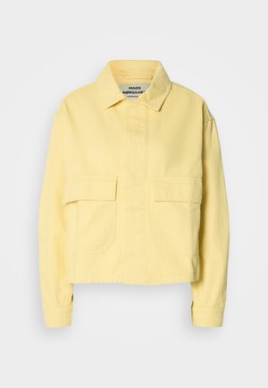 Żółta kurtka krótka wykonana z bawełny. Posiada klasyczny kołnierz, dwie przednie kieszenie naszywane oraz długie rękawy z zapięciem na guziki.