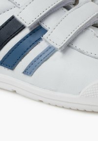 Scarpa in pelle bianca con accenti sintetici blu e navy, dotata di suola testurizzata e cinturini regolabili in velcro per la chiusura.