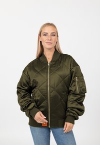 Giacca bomber trapuntata verde oliva con zip frontale, polsini a coste e tasca sulla manica. Realizzata in un tessuto liscio e lucido.