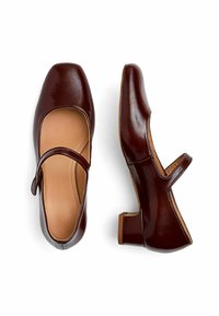 Scarpe Mary Jane in pelle marrone con punta quadrata, tacco basso a blocco e una cintura arrotondata sulla tomaia. Finitura liscia e lucida.