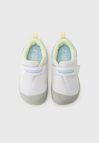 Baskets blanches en mesh avec des accents jaunes, doublure intérieure bleue, semelle grise et sangle réglable. Présente un logo Puma sur le côté.
