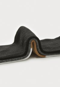 Κάλτσες από βισκόζη με μίγμα μαλλιού, εκτεθειμένες, με διπλωμένο σχέδιο σε μαύρο, γκρι, καφέ και λευκό χρώμα, επιδεικνύοντας υφή υφάσματος.