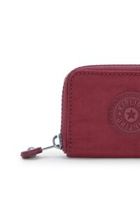 Portafoglio in tessuto rosso con finitura texturizzata, angoli arrotondati, chiusura con zip e dettaglio del logo impresso sul fronte.