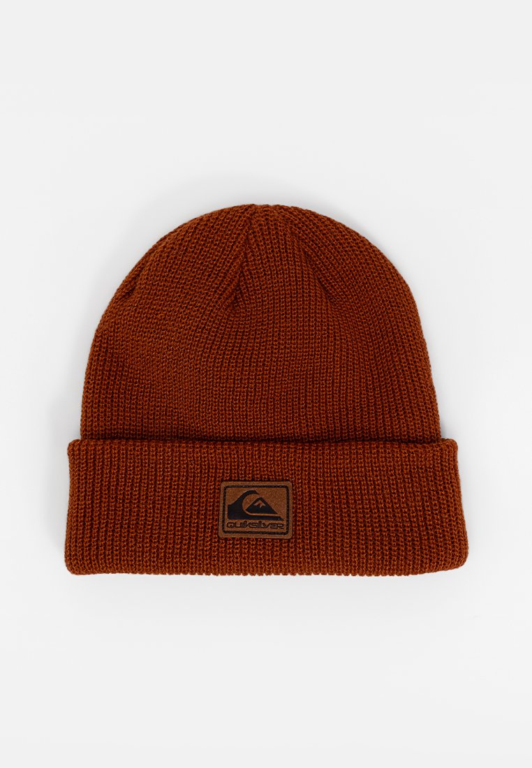 Gorro de punto color óxido con un dobladillo y un pequeño parche de logo negro con un diseño de montaña.