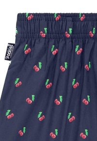 Tissu bleu marine avec un motif de cerises répétitif en rouge et vert. Ceinture élastique avec étiquette de marque sur le côté. Texture lisse.