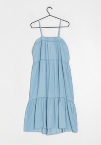 Vaaleansininen farkkumekko mustalla ripustimella, jossa on ohuet olkaimet, rypytetty vyötärö ja kerroksellinen, levenevä helma. Sileä pinta.