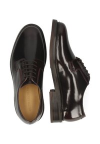 Scarpe oxford da uomo in pelle marrone scuro con finitura lucida, design con lacci e tacco impilato. L'interno presenta una fodera beige.