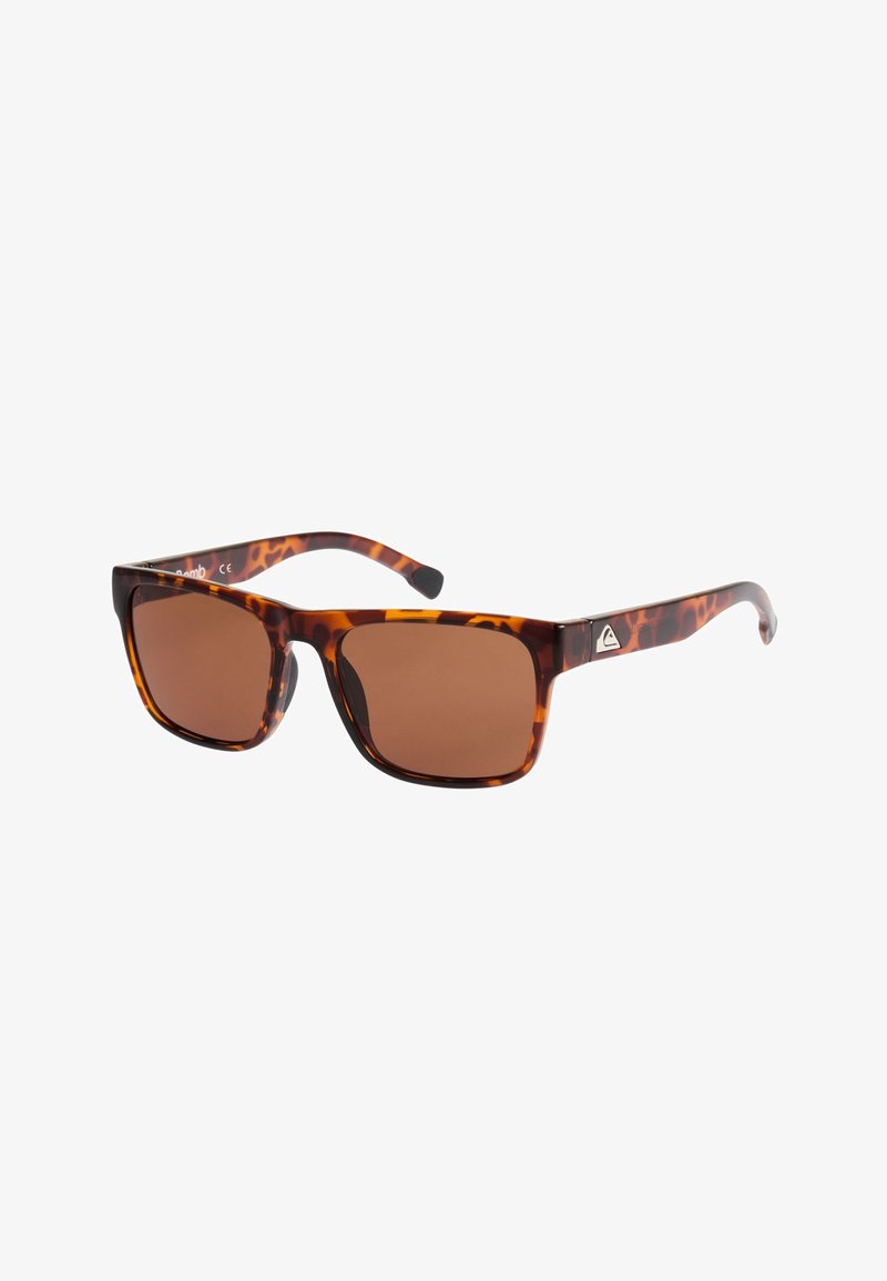 Lunettes de soleil rectangulaires en écaille de tortue avec des verres bruns et un petit logo argenté sur la branche, présentées en angle pour montrer le devant et le côté.
