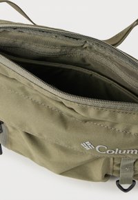 Ελιάς πράσινη τσάντα με φερμουάρ από ανθεκτικό ύφασμα, με εσωτερικούς χώρους και λογότυπο. Απλός σχεδιασμός με υφή στην επιφάνεια.