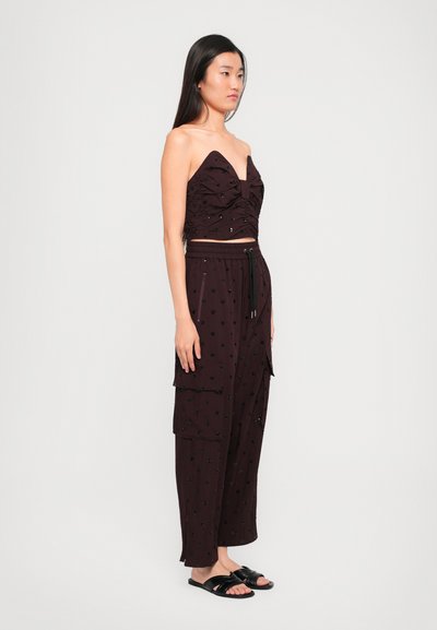 Bordó two-piece szett: redőzött, pánt nélküli felső, mély V-nyakkivágással, párosítva széles szárú cargo nadrággal, zsebekkel és gyöngyös díszítéssel.