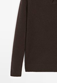 Maglione a maniche lunghe in maglia di colore marrone scuro con polsini e orlo a coste, mostrato su uno sfondo bianco.