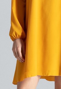 Gelbes, leichtes Kleid mit langen, gepufften Ärmeln und einem ausgestellten Saum, mit glatter Textur und minimalistischem Design.