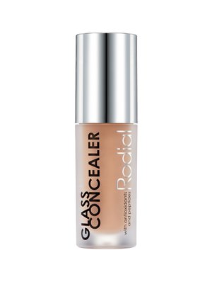Bottiglia di vetro trasparente con un cappuccio cilindrico argentato. Contiene un liquido beige chiaro etichettato "GLASS CONCEALER" e "Rodial" in carattere nero in grassetto.