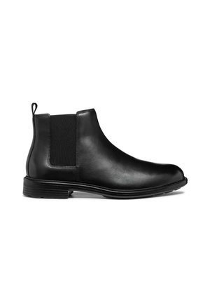 Bota Chelsea de cuero negro con paneles laterales elásticos, punta redonda y suela texturizada. Cuenta con una lengüeta para facilitar el calzado.