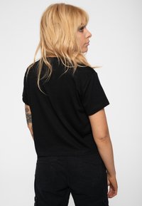 Black cotton t-shirt with short sleeves, a round neckline, and a relaxed fit. Features a plain design and smooth texture.