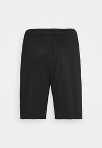 Shorts deportivos negros hechos de tela suave, con cintura elástica, corte a la altura de la rodilla y sin bolsillos ni adornos visibles.