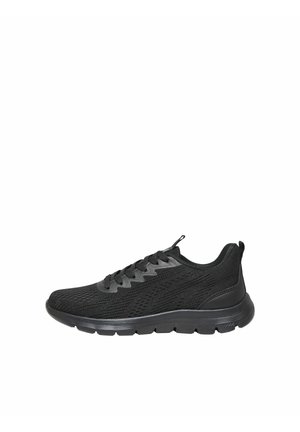 Basket de sport noire avec dessus en mesh, fermeture à lacets, semelle rembourrée et design bas, présentée de profil sur fond blanc.