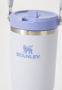 Light purple Stanley insulated tumbler with hinged lid and metal rim, featuring a winged lion logo and Stanley brand name.