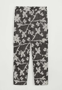 Pantalons à motif noir et blanc avec un design floral, dotés de poches latérales et d'un tissu texturé. Le motif évoque des branches et des feuilles.