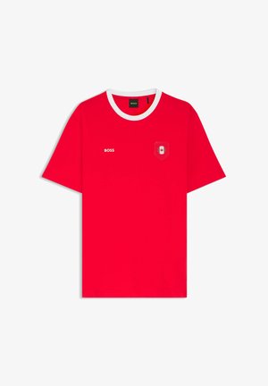 Rotes T-Shirt mit kurzen Ärmeln und weißem Kragen, mit dem Schriftzug "BOSS" auf der linken Brust und einem Aufnäher mit Ahornblatt auf der rechten Brust.