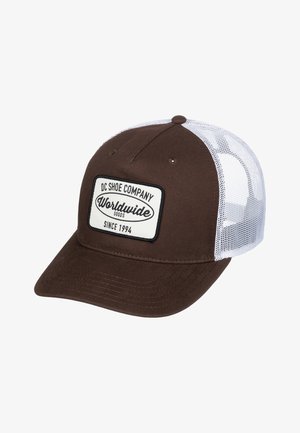 Gorra de béisbol marrón con una parte trasera de malla blanca, que presenta un parche rectangular etiquetado "DC SHOE COMPANY" y "WORLDWIDE GOODS" en texto negro.