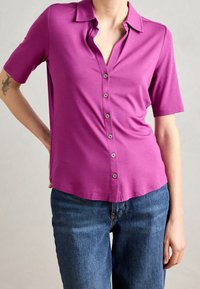 Korte mouw, knoopsluiting shirt in levendig magenta, met een klassieke kraag, een gladde textuur en een subtiele glans. Gepaard met denim.