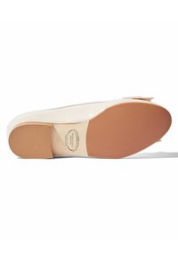 Bailarina de color claro con punta redondeada, acabado brillante y suela en suave tono beige. Presenta un pequeño lazo en la parte delantera.