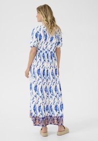 Maxi sukienka z lekkiego materiału, z niebieskim kwiatowym wzorem na białym tle oraz wzorzystym dołem. Elastyczny pas, krótkie rękawy.