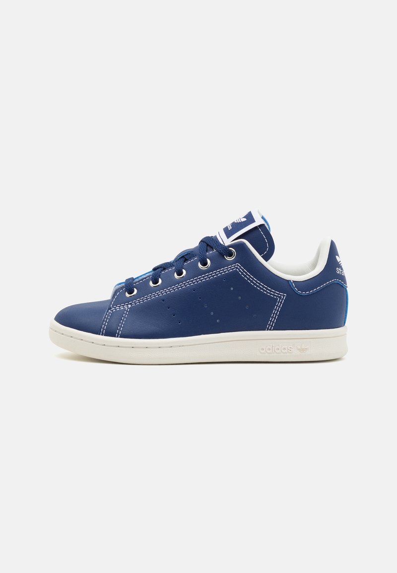 Navy blue leather sneakers with white accents, round toe, lace closure, and perforated detailing on the sides. Logo on tongue and heel.