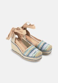 Alpargatas de cuña con un upper tejido multicolor, suela de yute natural y cintas beige para un ajuste seguro en el tobillo.