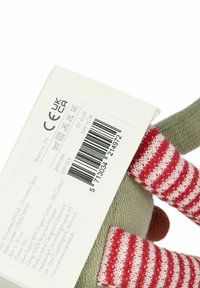 Cotton doll with green body, red striped legs, and brown nose. Tag displays care instructions, barcode, and product details.