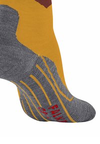 Calzino giallo e grigio con grip testurizzato sulla suola, caratterizzato da marcature rosse e un motivo che include onde e un accento bordeaux nella parte superiore.